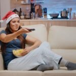 Una persona atenta a la televisión con gorro navideño