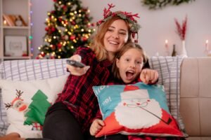 Una persona con el mando del televisor en un salón navideño